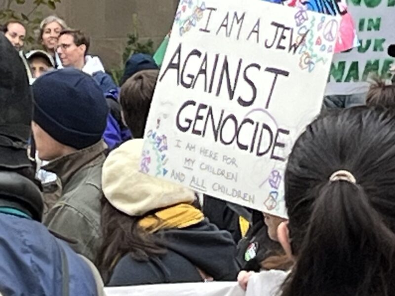 A protest sign calling for an end to genocide.