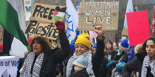 Women at the 2024 International Women's Day march holding signs in support of the Palestinian women of Gaza.