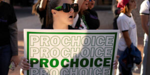 Person holds a sign reading "prochoice" at a protest in Arizona.