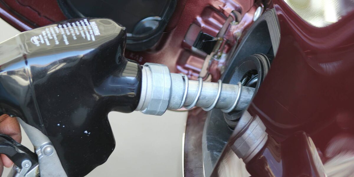 A person putting gas in their car from a pump station.