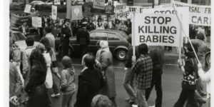 Police vehicles separate supporters and opponents of abortion rights marching in Toronto (10 May 1981).