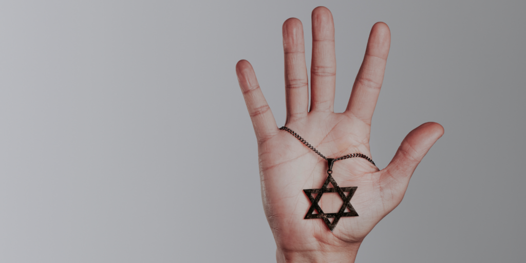 A hand holding a Star of David.