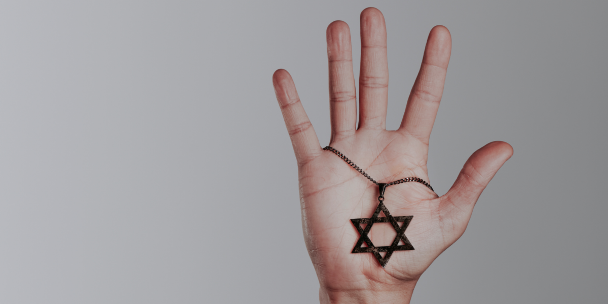 A hand holding a Star of David.