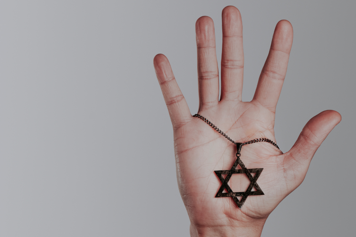 A hand holding a Star of David.