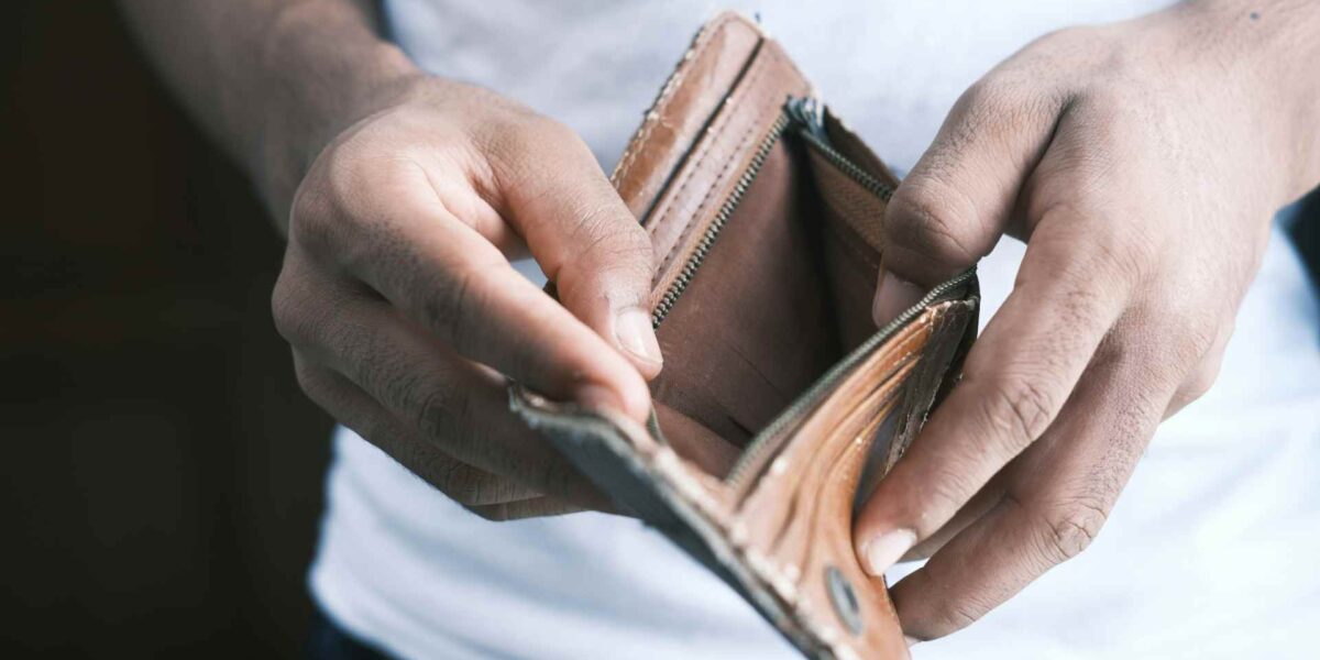 A person opening an empty wallet.