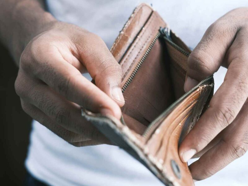 A person opening an empty wallet.