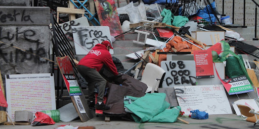 A man sifts through the materials left behind by uOttawa encampment participants.