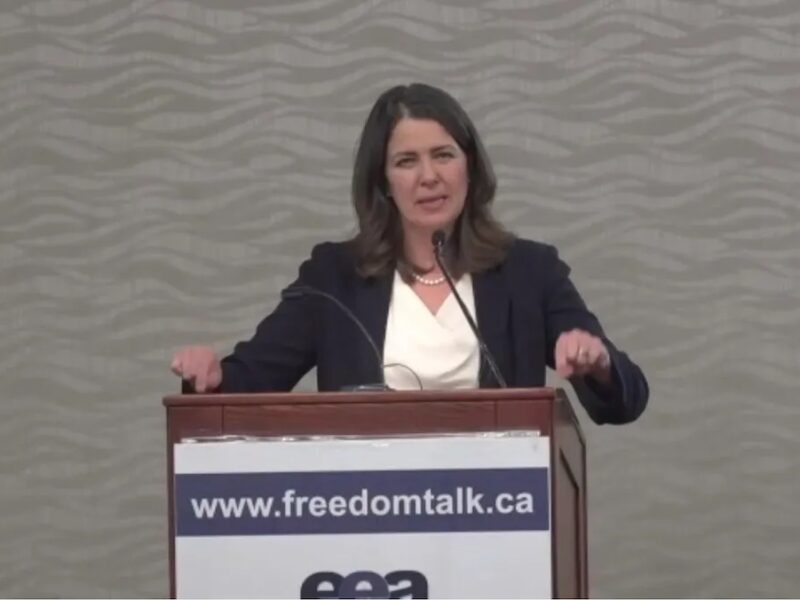 Danielle Smith stands at a podium at a libertarian conference on health care in the fall of 2021.