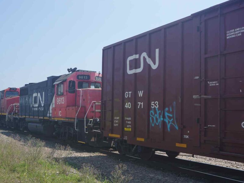 A CN train travelling down tracks.