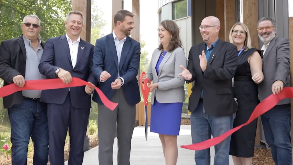 Premier Danielle Smith cuts the ribbon with a giant pair of scissors at the “Lakeview Recovery Community” west of Edmonton.