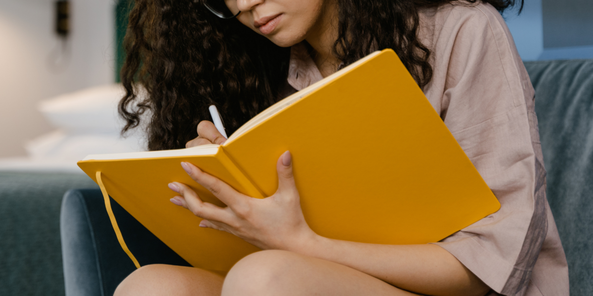 A person holding a large yellow notebook.