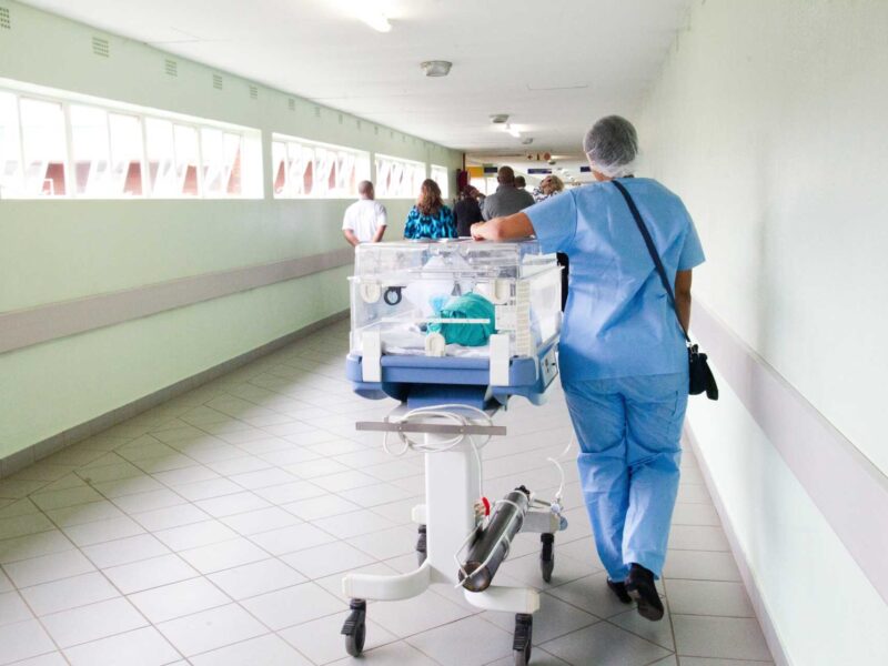 A nurse walking the hallway of a hospital.