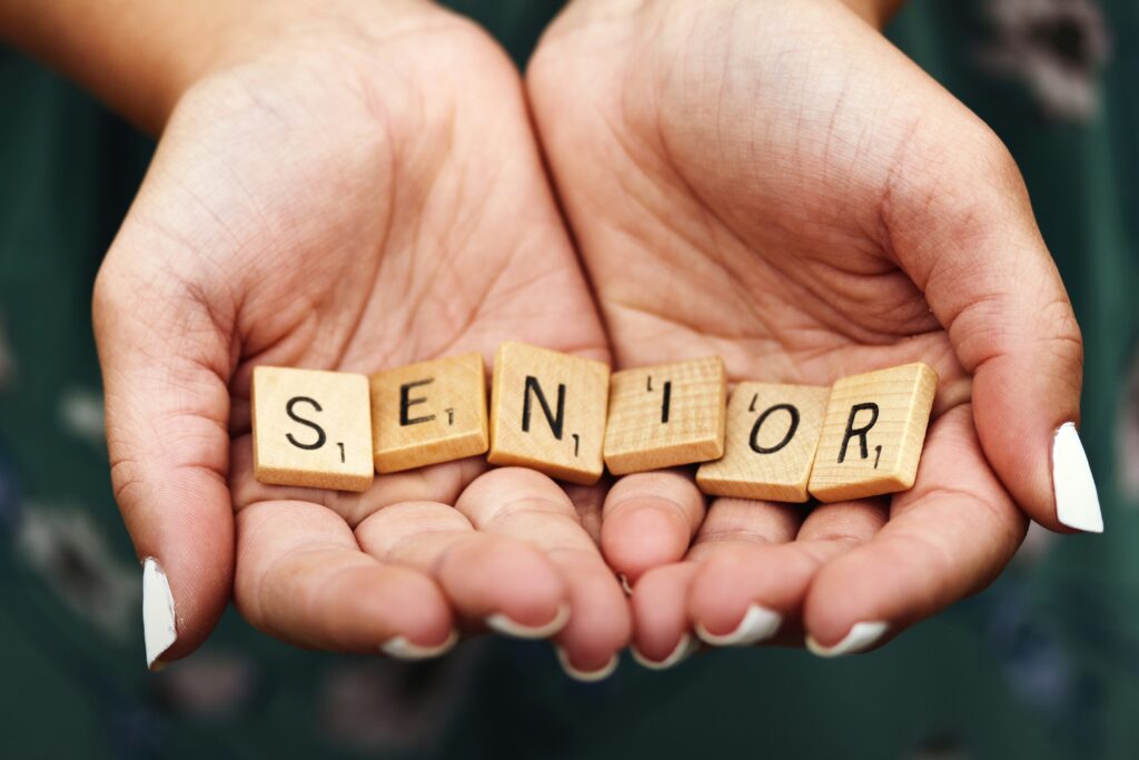 Cupped hands with letters spelling "senior."