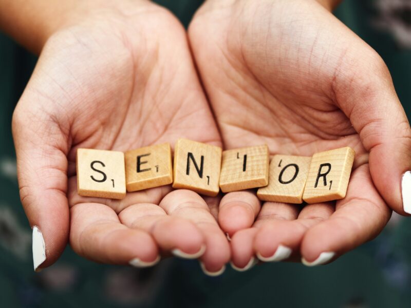 Cupped hands with letters spelling "senior."