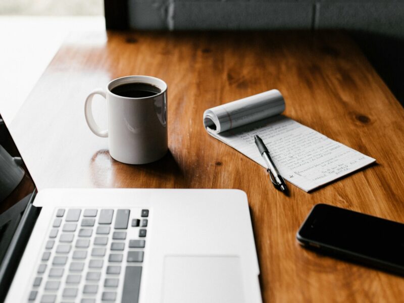 An image of a laptop and note pad on a desk. PSAC says public service workers have experienced firsthand the benefits of telework.