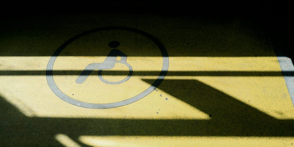 A wheelchair symbol on the ground, in shadow.