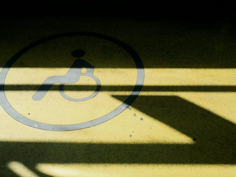 A wheelchair symbol on the ground, in shadow.