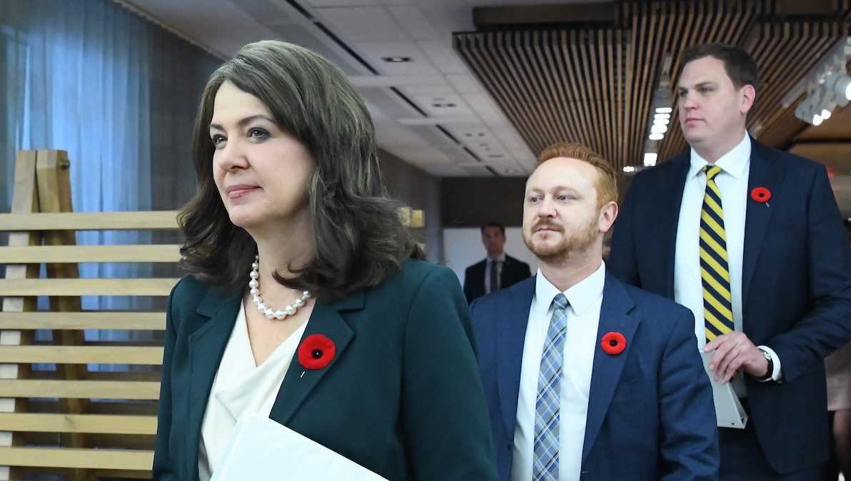 Alberta Premier Danielle Smith and her justice minister, Mickey Amery, and sports minister, Joseph Schow, march into their Halloween newser on Alberta’s harsh transgender legislation.