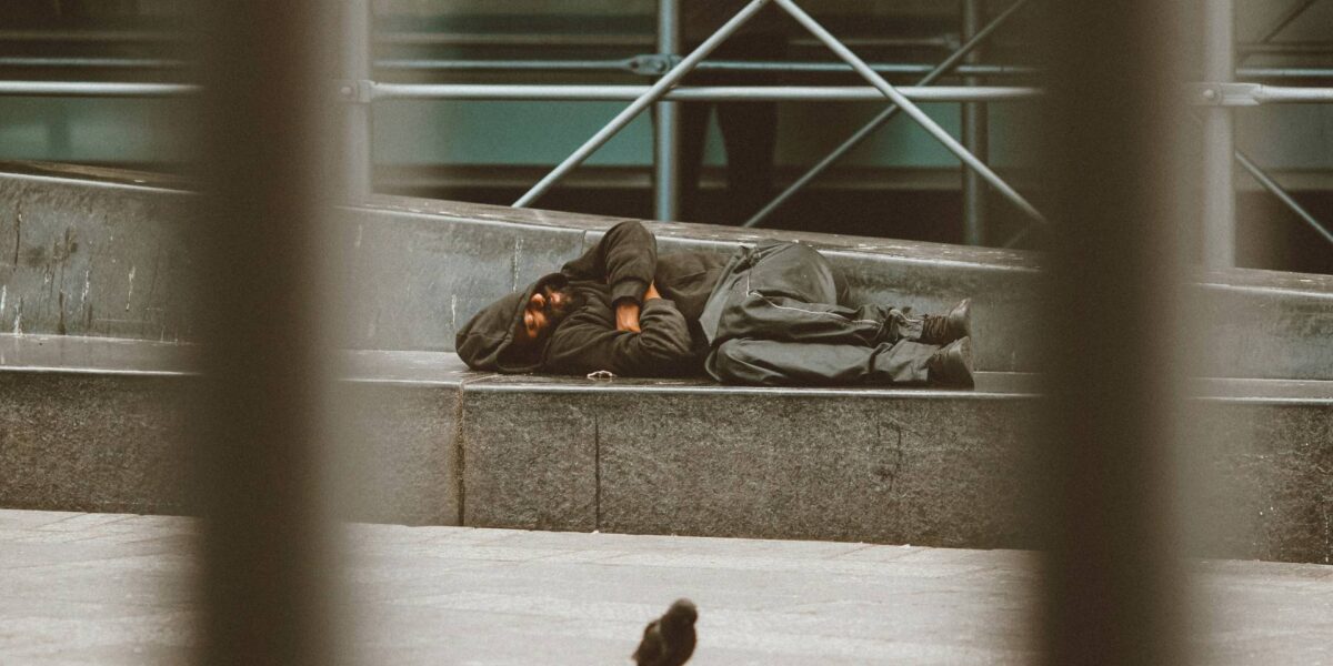 A man sleeps on the street.