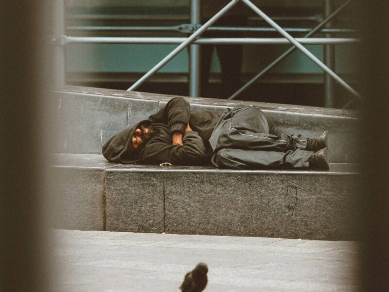 A man sleeps on the street.