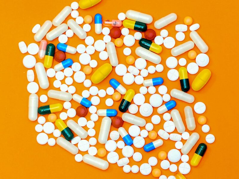 An image of pills on an orange background. Linda Silas has been appointed to a committee guiding the next phase of pharmacare.