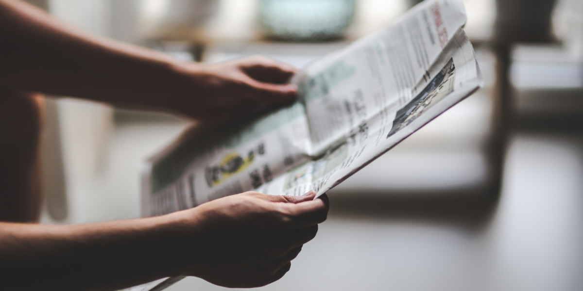 A person holding a newspaper.