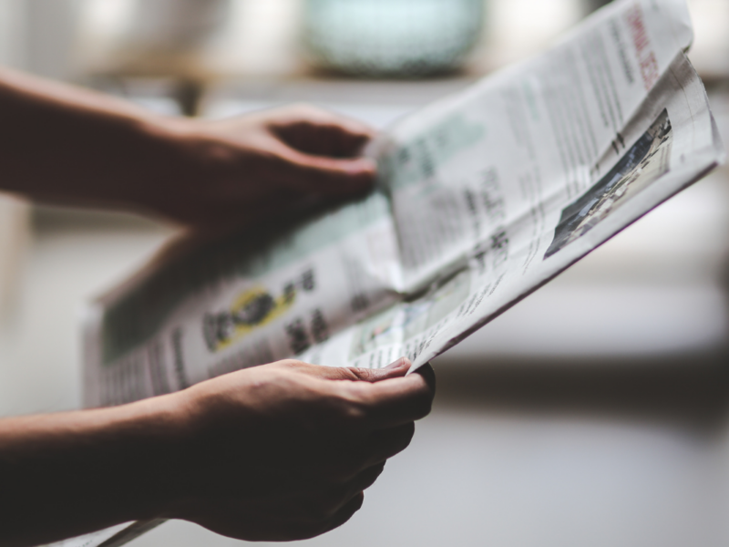 A person holding a newspaper.