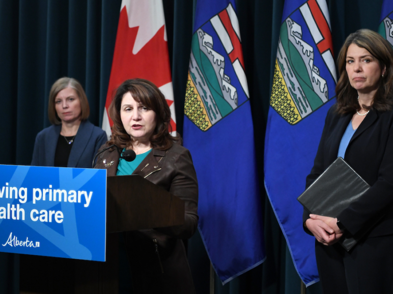 Health Minister Adriana LaGrange at the microphone, flanked by Alberta Medical Association President Shelley Duggan and Premier Danielle Smith at a news conference on physician pay.