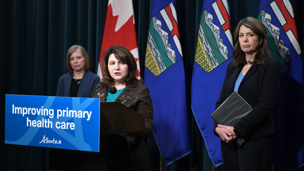 Health Minister Adriana LaGrange at the microphone, flanked by Alberta Medical Association President Shelley Duggan and Premier Danielle Smith at a news conference on physician pay.