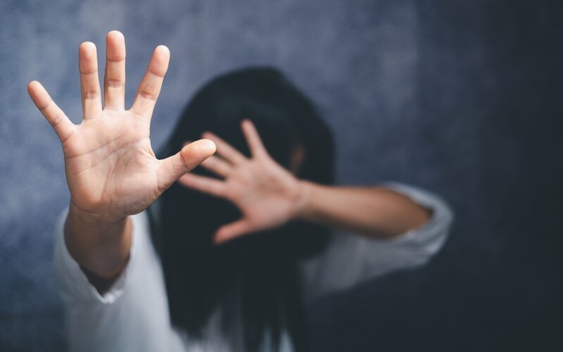 A woman holds her hands away from her face.