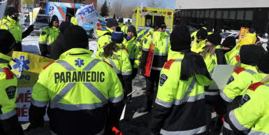 A crowd of paramedics with their backs to the camera. Quebec prehospital workers reached an agreement where members get a six per cent wage increase.