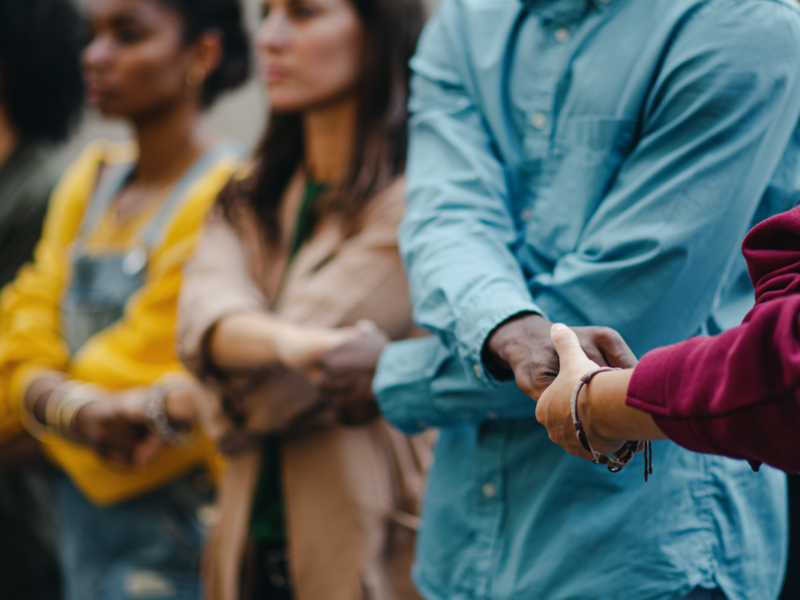 A group of folks holding hands in solidarity.