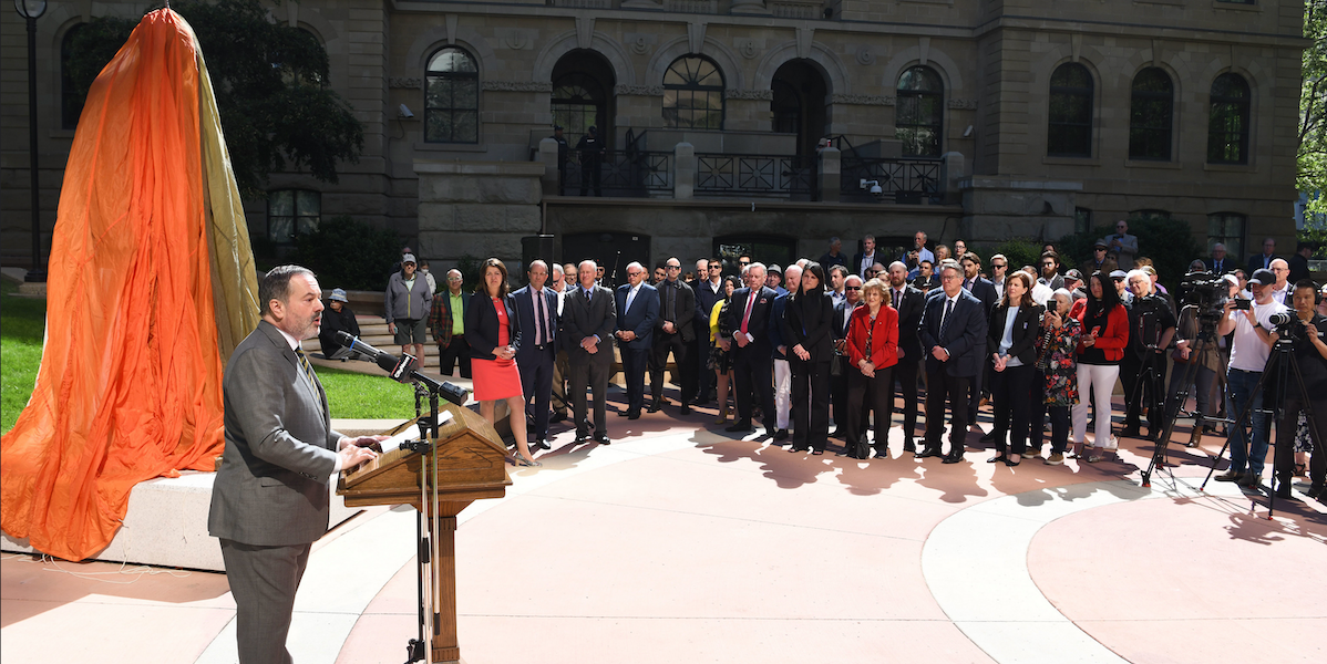 Former Alberta Premier Jason Kenney before a still-veiled statue of Winston Churchill in Calgary in June 2024.