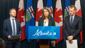 Alberta Premier Danielle Smith, flanked by Justice Minister Mickey Amery and Public Safety Minister Mike Ellis, all looking very, very serious at Wednesday's news conference.