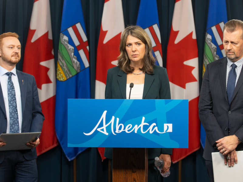 Alberta Premier Danielle Smith, flanked by Justice Minister Mickey Amery and Public Safety Minister Mike Ellis, all looking very, very serious at Wednesday's news conference.