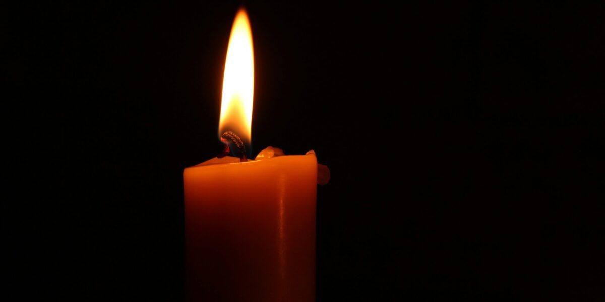 A candle on a black background.