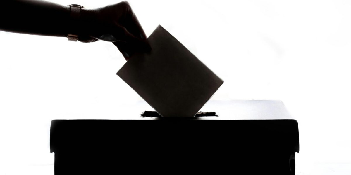 A ballot going into a box.