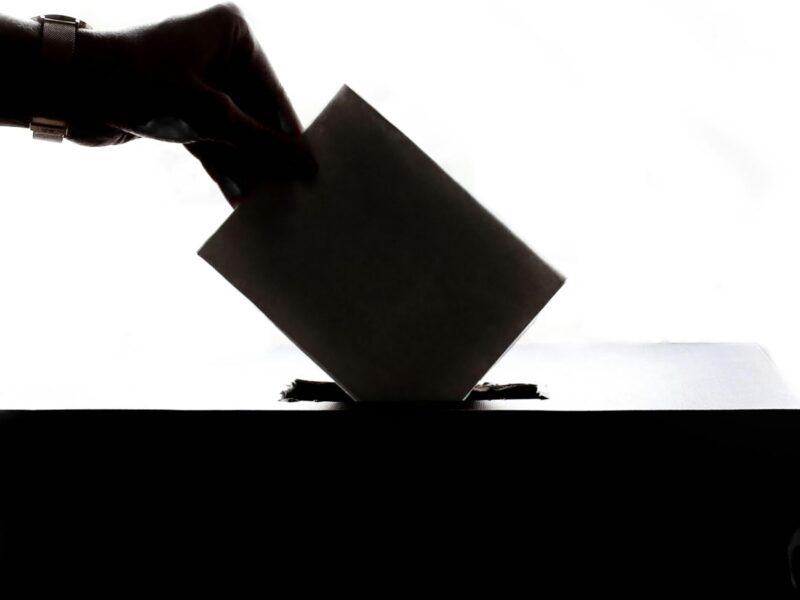 A ballot going into a box.