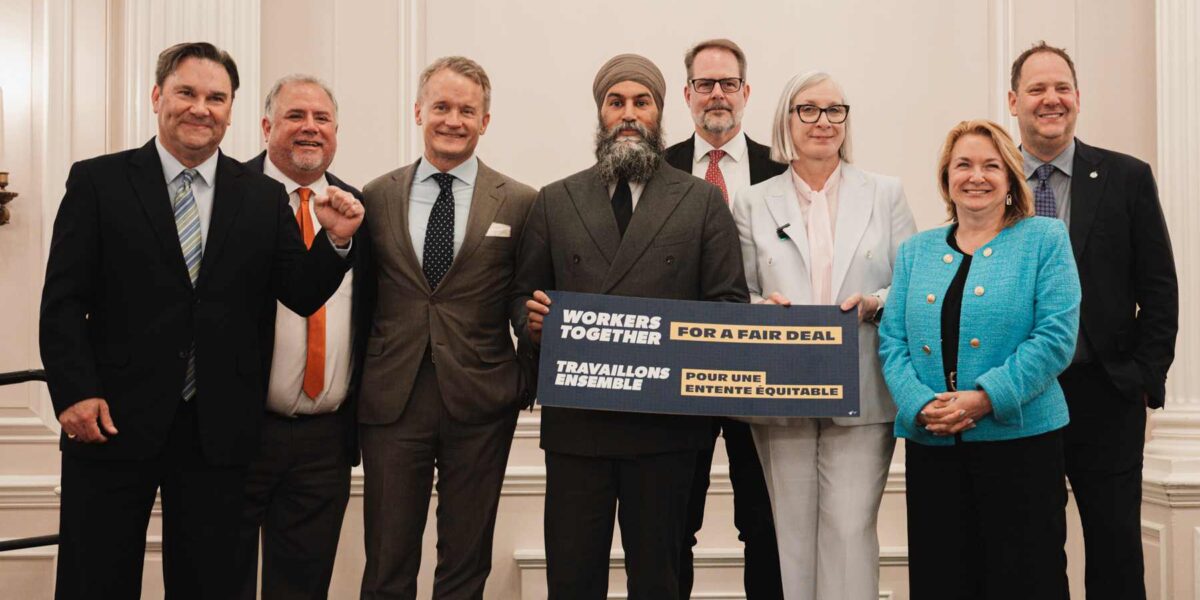 Labour leaders alongside Liberal and NDP party members celebrating the implementation of Bill C-58.