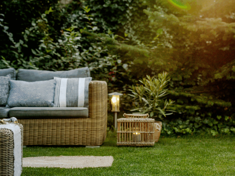 An image of a backyard with a neatly trimmed lawn and some outdoor furniture.