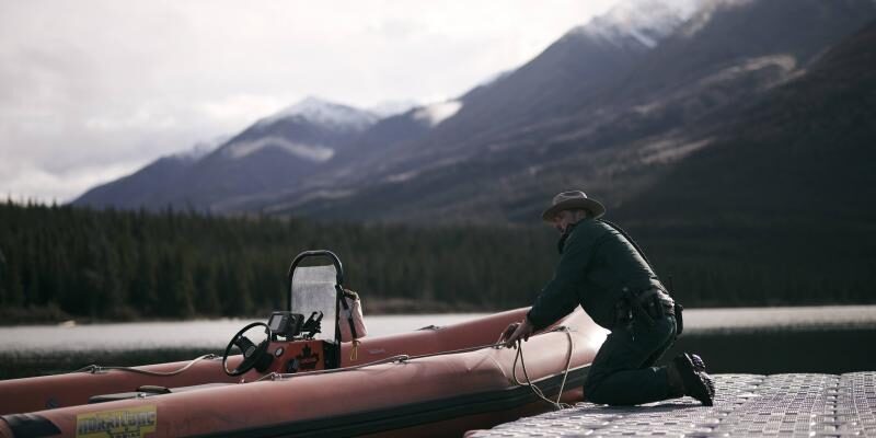 An image of a lone man fiddling with a boat at a park. The government of Canada introduced the Canada Strong Pass, which provides free admission to parks and museums, but did not introduce more funding or hiring for eligible sites.