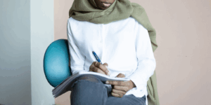 A person writing something on a pad of paper.