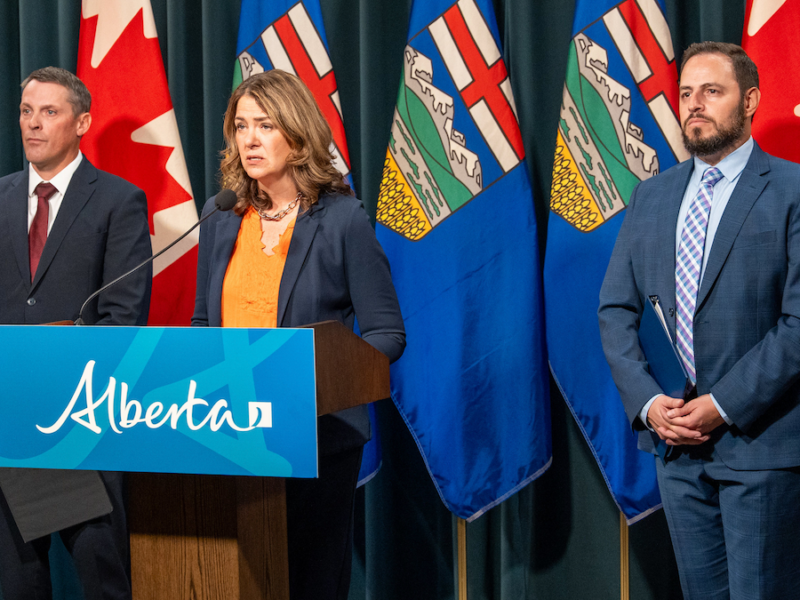 A grim-faced Alberta Premier Danielle Smith, flanked by her grim-faced ministers of finance and education, Nate Horner and Demetrios Nicolaides, explains her government’s scheme to pay parents to teach their kids at home during a teachers’ strike.