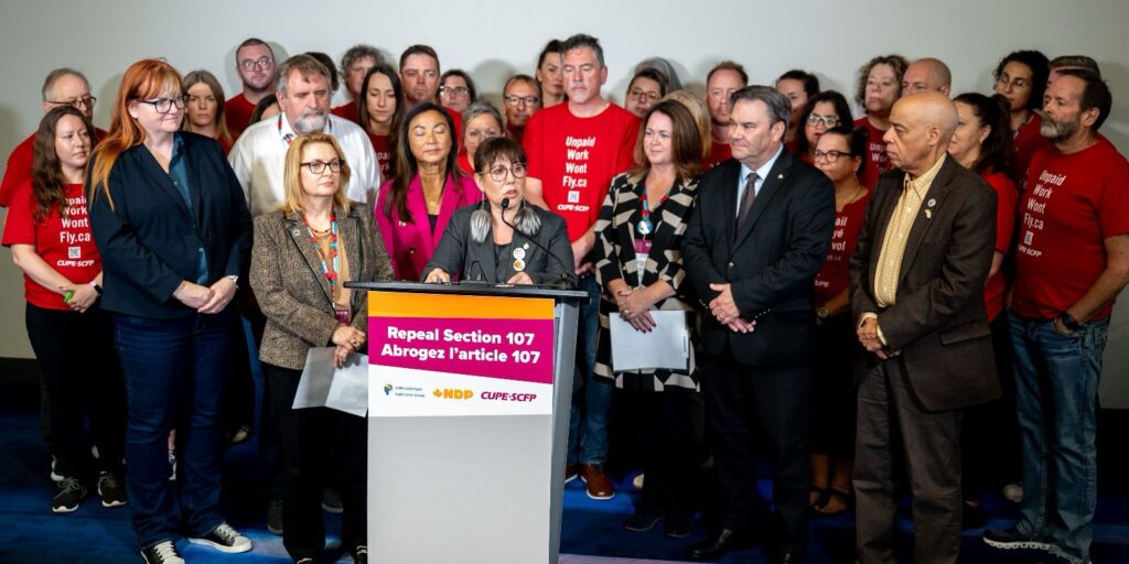 NDP MP Leah Gazan surrounded by labour leaders at a press conference announcing legislation to repeal section 107.