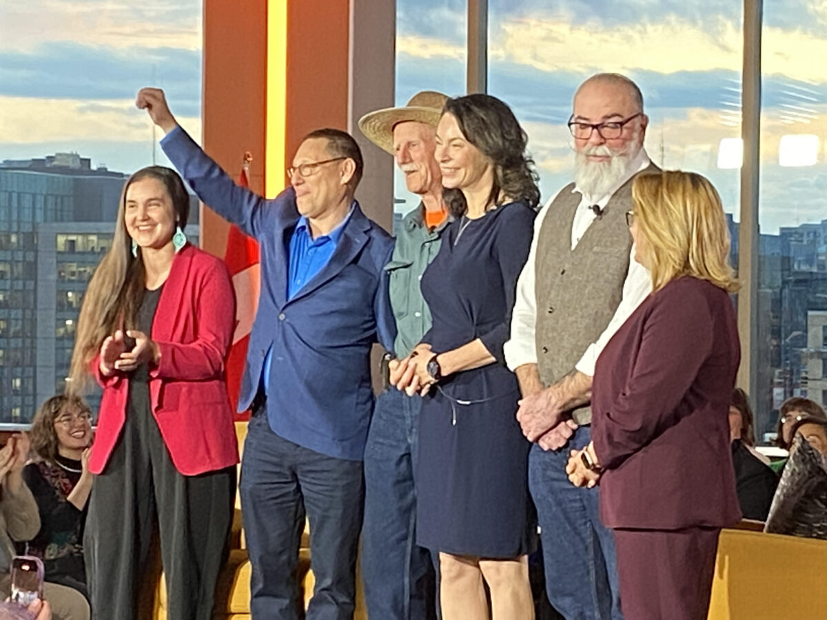 NDP leadership candidates stand on stage with CLC president Bea Bruske.