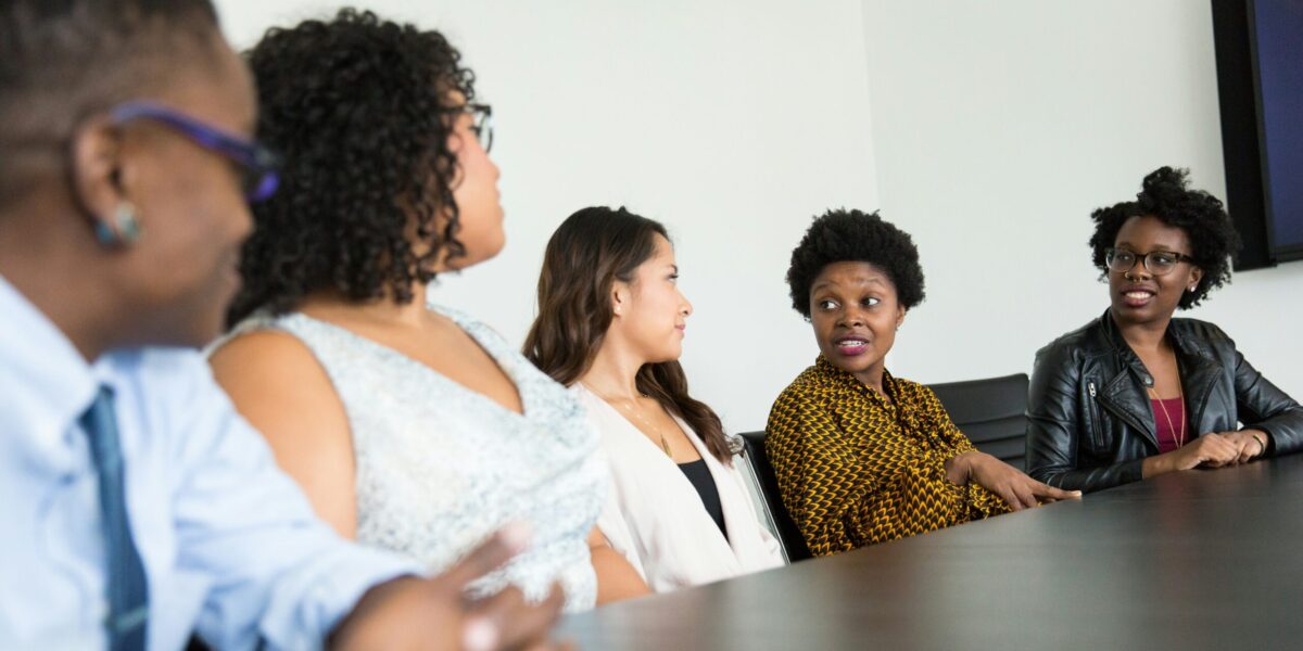 Women in discussion at a table.