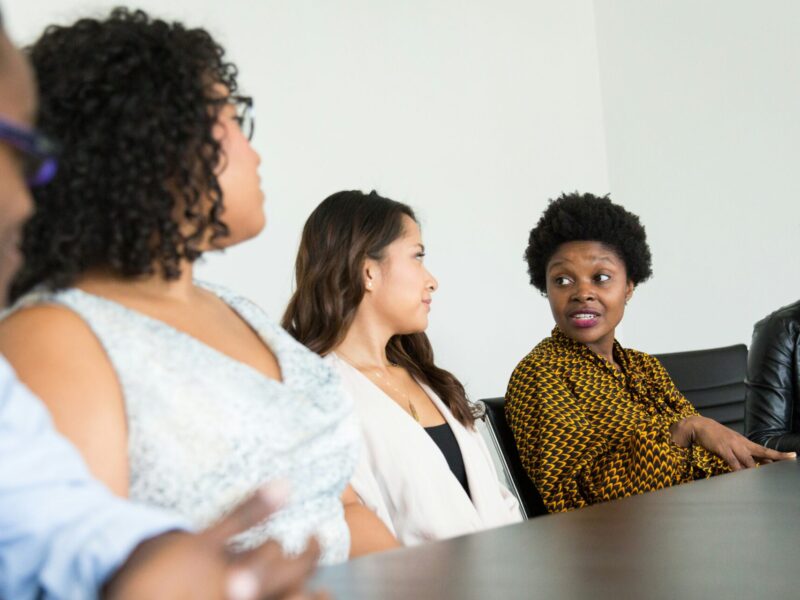 Women in discussion at a table.