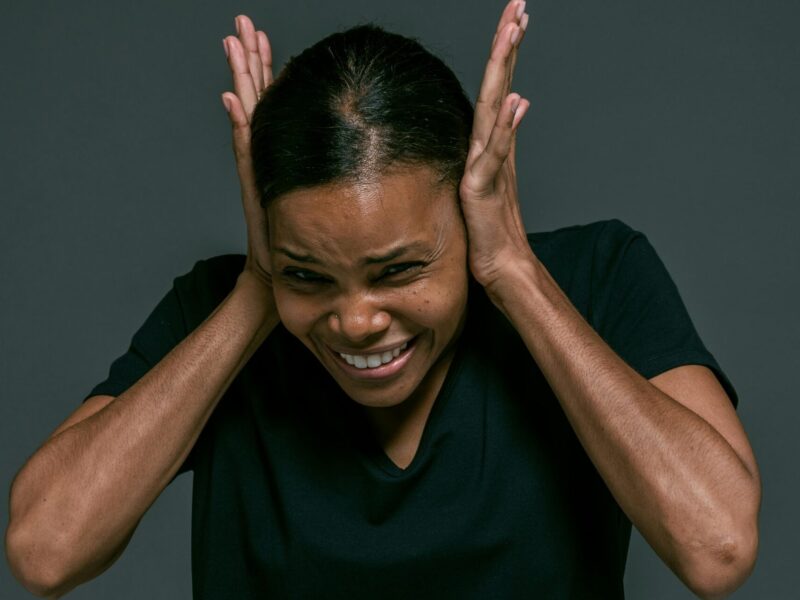 A woman covers her ears.