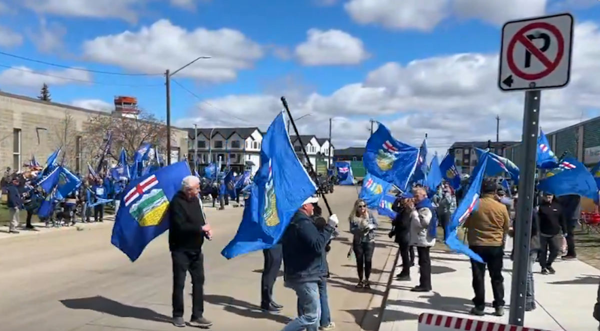 Flag-waving supporters of the Stay Free Alberta petition gathered at Elections Alberta’s headquarters in Edmonton on Monday.