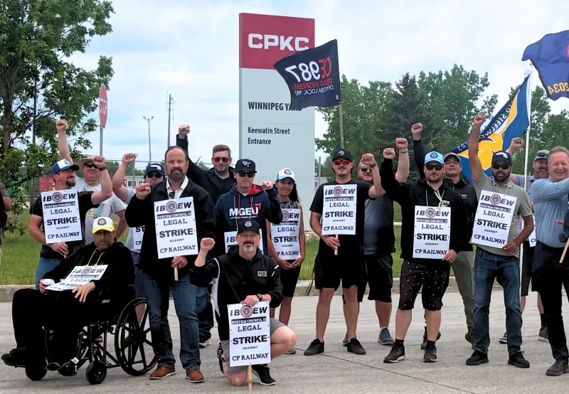 Workers represented by the International Brotherhood of Electrical Workers System Council 11 on the picket line.
